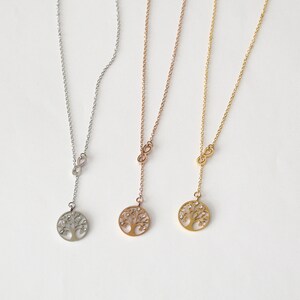 May include: Three silver, rose gold, and gold necklaces with an infinity symbol and a tree of life pendant. Each pendant has small clear stones.
