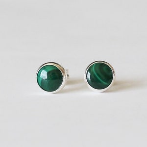 May include: A pair of silver stud earrings with round green malachite stones.