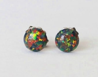 May include: A pair of silver stud earrings with round black opal stones. The opals have a multi-coloured iridescent effect.