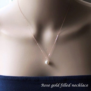 May include: A delicate rose gold filled necklace with a single pearl pendant.