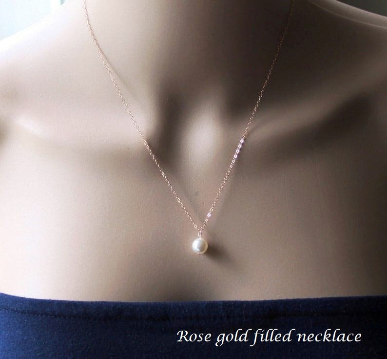 May include: A delicate rose gold filled necklace with a single pearl pendant.