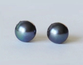 May include: A pair of black pearl stud earrings. The pearls are round and have a slight iridescent sheen.