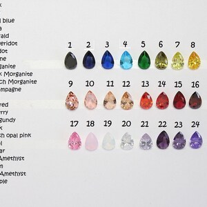 May include: Chart of 24 teardrop-shaped gemstones in various colors, numbered 1 through 24. The colors include black, navy, royal blue, aqua, emerald, peridot, citrine, morganite, pink morganite, peach morganite, champagne, red, dark red, cherry, burgundy, pink, blush opal pink, opal, clear, light amethyst, plum, dark amethyst, and purple.