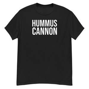 May include: Black t-shirt with the white text "HUMMUS CANNON" printed across the chest. The shirt is a classic crew neck style, made of a soft material.