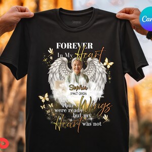 May include: Black t-shirt with a memorial design. The design includes a photo of a woman with angel wings, butterflies, and the text "FOREVER In My Heart". The shirt also includes the name "Sophia 1967-2026" and the words "Your wings were ready but my heart was not."