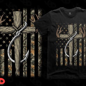 May include: Black t-shirt featuring a graphic design with a wooden cross, fishing hook, and deer antlers. The design incorporates elements of the American flag, with stars and stripes, and a camouflage pattern.