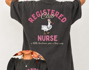 May include: A charcoal gray short-sleeve t-shirt featuring a back graphic of a goose wearing a nurse hat with the text Registered Nurse Club and a little kindness goes a long way. The front chest displays the text RN Nurse Club est. 2026.