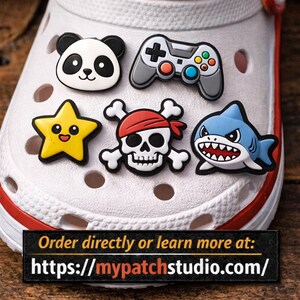 May include: A collection of decorative shoe charms, including a panda face, a video game controller, a yellow star, a skull and crossbones, and a blue shark. The charms are attached to a white shoe.
