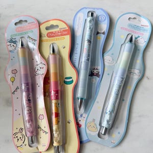 May include: Four mechanical pencils in individual blister packaging, each labeled PlayBorder and 0.5mm. The pencils feature colorful, segmented barrels with various cartoon character graphics, including Winnie the Pooh and other figures, set against pastel-colored cardboard backings with matching illustrations.