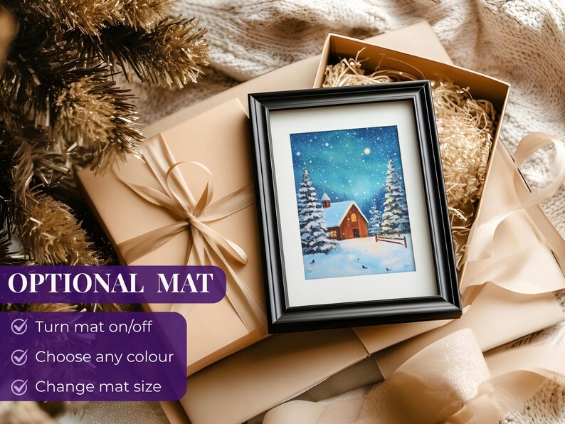 May include: A framed winter landscape painting with a red cabin, snow-covered trees, and a starry sky. The painting is in a black frame, resting on a gift box with a beige ribbon. The words "OPTIONAL MAT" are visible.