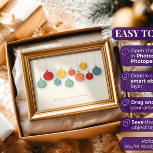 May include: A framed Christmas art print featuring colorful hanging ornaments. The gold frame sits in an open gift box with a gold bow. The text "MERRY CHRISTMAS" is at the bottom of the print. Instructions on how to use the art are on the right.