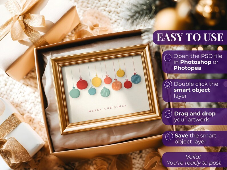 May include: A framed Christmas art print featuring colorful hanging ornaments. The gold frame sits in an open gift box with a gold bow. The text "MERRY CHRISTMAS" is at the bottom of the print. Instructions on how to use the art are on the right.