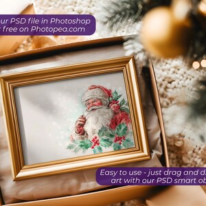 May include: A framed Christmas print featuring Santa Claus in a red suit and white beard, surrounded by holly. The gold frame sits in a gift box. Text on the image reads: "Use your PSD file in Photoshop or for free on Photopea.com" and "Easy to use - just drag and drop your art with our PSD smart objects."