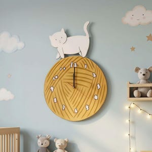 Könnte beinhalten: Eine skurrile Wanduhr mit Katzenmotiv. Die Uhr zeigt eine weiße Katzenfigur, die auf einem gelben Zifferblatt sitzt, das wie ein Wollknäuel gestaltet ist. Die Zeiger der Uhr sind schwarz. Der Hintergrund ist hellblau mit Wolken- und Sternendekorationen.