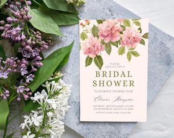 Può includere: Un invito per un bridal shower con accenti floreali rosa e il testo "PLEASE JOIN US FOR A BRIDAL SHOWER". L'invito è su uno sfondo rosa chiaro, con fiori lilla e bianchi sullo sfondo.