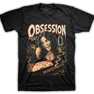 May include: A black short-sleeve t-shirt featuring a graphic print with the text "OBSESSION" and "YOU ONLY GET ONE WISH" above an illustration of a smiling person with dark hair, a smaller figure, and a box labeled "ONE WISH WILLOW" with smoke.