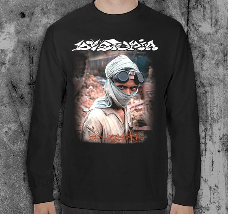 K&ouml;nnte beinhalten: Schwarzes Langarm-T-Shirt mit einem Grafikdruck einer Person mit Gesichtsmaske und Schutzbrille. Der Text "Dystopia" ist in Wei&szlig; auf dem Shirt gedruckt.
