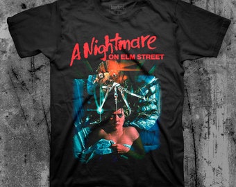 May include: Black t-shirt with a graphic print of a scene from the movie "A Nightmare on Elm Street". The graphic features Freddy Krueger with his bladed glove and a young woman in bed.