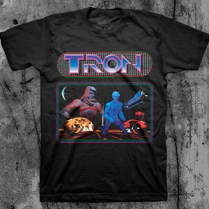 May include: Black t-shirt with a graphic of the word "TRON" in a retro video game style. The graphic features characters and a light cycle from the movie Tron.