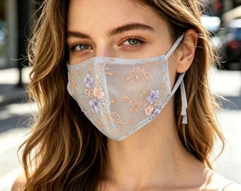 Elegante mascherina protettiva solare con ricami floreali, realizzata in tessuto a rete traspirante per l'estate, con design aderente e protezione dalla polvere.