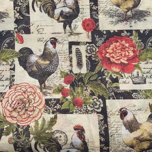 Op de afbeelding: Stof met een herhalend patroon met hanen, bloemen en schrift op een cr&egrave;me- en zwarte achtergrond. De hanen worden in verschillende poses afgebeeld, met rode kammen en gedetailleerde veren. Rode en cr&egrave;mekleurige bloemen en groene bladeren zijn ook aanwezig.