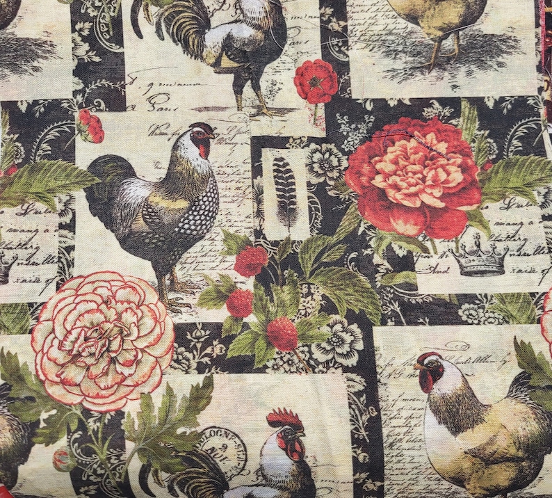Op de afbeelding: Stof met een herhalend patroon met hanen, bloemen en schrift op een cr&egrave;me- en zwarte achtergrond. De hanen worden in verschillende poses afgebeeld, met rode kammen en gedetailleerde veren. Rode en cr&egrave;mekleurige bloemen en groene bladeren zijn ook aanwezig.