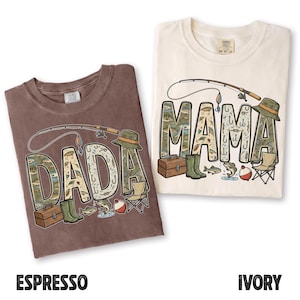 May include: Two t-shirts, one espresso and one ivory, with fishing-themed designs. The espresso shirt says "DADA" and the ivory shirt says "MAMA", both in a font filled with fishing-related illustrations. Each design includes a fishing rod, hat, boots, and other fishing accessories.