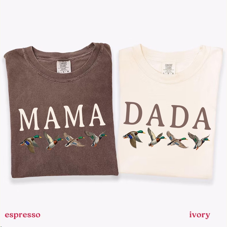 Pu&ograve; includere: Due magliette a maniche corte nei colori espresso e avorio. La maglietta espresso presenta la scritta MAMA in bianco con quattro germani reali in volo sotto. La maglietta avorio presenta la scritta DADA in marrone con quattro germani reali in volo.
