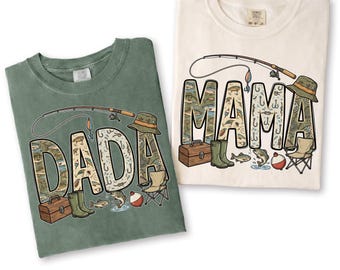 Könnte beinhalten: Zwei T-Shirts, eines in Moosgrün und eines in Elfenbein, mit Angelmotiven. Das grüne Shirt zeigt "DADA", das elfenbeinfarbene Shirt "MAMA". Beide zeigen Angelruten, Hüte und Angelgrafiken. Ein charmantes Geschenk für Angelfreunde.