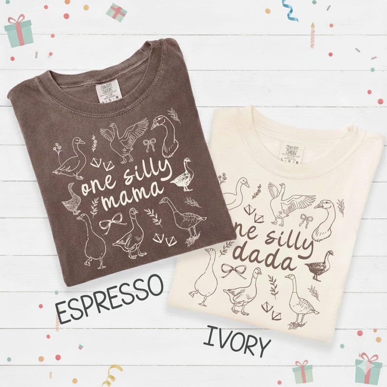 Puede incluir: Dos camisetas, una espresso y otra marfil, con un gr&aacute;fico de ganso y las frases "one silly mama" y "one silly dada". Las camisetas tienen cuello redondo y mangas cortas. La camiseta espresso es de color marr&oacute;n oscuro, y la camiseta marfil es blanquecina.