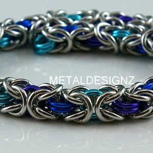 May include: A silver chainmail bracelet with blue and purple accents. The bracelet is made of interwoven metal rings.