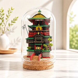 K&ouml;nnte beinhalten: Ein Miniaturmodell eines mehrst&ouml;ckigen Geb&auml;udes mit roten, gr&uuml;nen und gelben architektonischen Details, eingeschlossen in einer klaren Glaskuppel auf einem Korksockel. Das Bauwerk zeigt eine kleine rote Br&uuml;cke, eine Flagge mit dem Zeichen 油 und ein Schild mit dem Text 油屋.