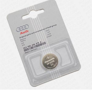 May include: A silver and gray Audi-branded package containing a Panasonic CR2032 3V battery. The package includes text in multiple languages, including "battery" and "Made in Germany."