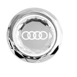 以下が含まれることがあります： 白のAudiロゴが入った、ファセット加工されたシルバーカラーのカーアクセサリー。エンブレムは4つのインターロッキングリングと方向矢印が特徴です。白い背景に対して、反射的で宝石のような外観をしています。