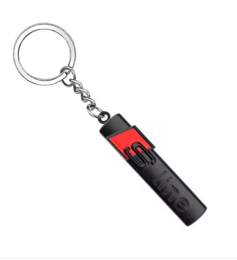 May include: A black and red S line keyring with a silver key ring and chain. The keyring has a rectangular shape with the S line logo in black and a red accent. The key ring and chain are made of silver metal.