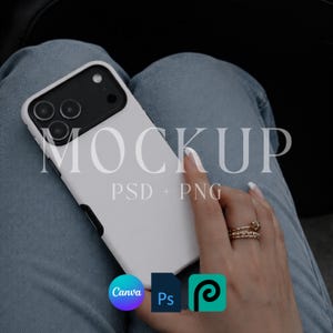May include: A white phone case with a black camera module is held by a person wearing rings. The phone case has the word "MOCKUP" printed on it, along with "PSD + PNG". Icons for Canva, Photoshop, and PicsArt are also visible.