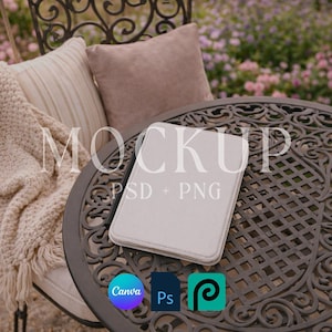 Puede incluir: Una funda de tableta gris claro descansa sobre una mesa de metal decorativa. La mesa está rodeada de muebles de exterior, incluyendo una silla con cojines y una manta. La palabra "MOCKUP" se muestra en la imagen, junto con "PSD + PNG" y los logotipos de Canva, Photoshop y Procreate.