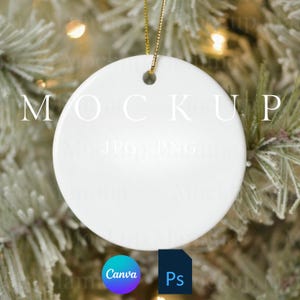 Könnte beinhalten: Ein weißer, runder Keramik-Weihnachtsschmuck mit einer goldenen Schnur zum Aufhängen. Das Wort "MOCKUP" ist auf dem Ornament aufgedruckt. Der Hintergrund ist ein verschwommenes Bild eines Weihnachtsbaums. Die Canva- und Ps-Logos befinden sich unten links.