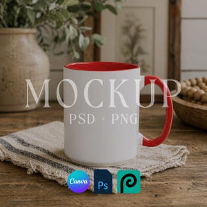 May include: White ceramic mug with a red interior and handle. The word "MOCKUP" is printed on the mug. The mug is sitting on a beige and gray striped cloth. Canva, Photoshop, and Procreate logos are visible.