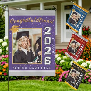 May include: A graduation garden flag with a photo of a graduate in a cap and gown, the text "Congratulations!" and "Class of 2026". Additional flags in blue, red, and yellow with the same design are also visible.