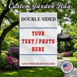 May include: A white, double-sided garden flag with the text "YOUR TEXT / PHOTO HERE" in red. The flag also features the text "DOUBLE SIDED" and "FLAG STANDS ARE NOT INCLUDED". The flag is displayed outdoors.