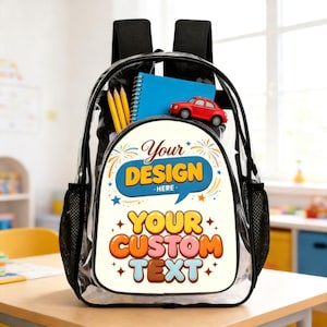 May include: A clear plastic backpack with black trim and straps. The front pocket features a white panel printed with the text Your DESIGN HERE and YOUR CUSTOM TEXT in colorful bubble letters. Inside are three yellow pencils, a blue notebook, and a red toy car.