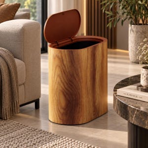 May include: An oval-shaped trash can with a wood grain finish and a hinged lid. The exterior features a light brown wood pattern, while the interior and the underside of the lid are a solid dark brown color. The lid is positioned in an open state.