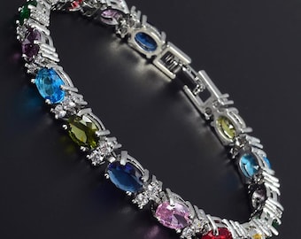 RIZILIA Oval Cut Multi-Color CZ Birthstone 18K White Gold Plated Tennis Bracelet, 7"