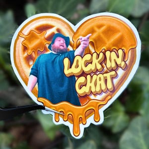 May include: A heart-shaped sticker featuring a man in a blue shirt and hat pointing to the right, set against a waffle background with dripping syrup. The text "LOCK IN CHAT" is in yellow.