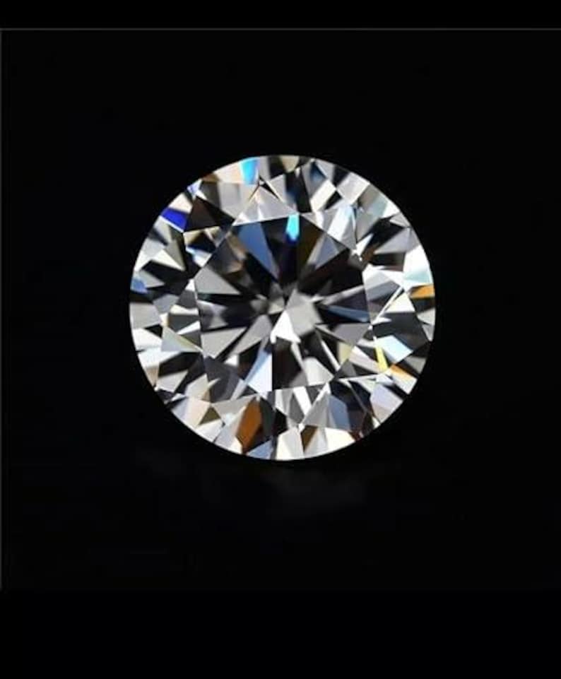 Puede incluir: Un diamante de talla redonda con m&uacute;ltiples facetas, que refleja la luz creando un juego de colores brillante. La gema se presenta sobre un fondo negro, resaltando su claridad y brillo. Un s&iacute;mbolo atemporal de lujo y elegancia.