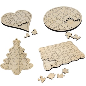 Op de afbeelding: Vier onafgewerkte houten puzzels in verschillende vormen: een hart, een cirkel, een kerstboom en een rechthoek. Elke puzzel mist een paar stukjes.