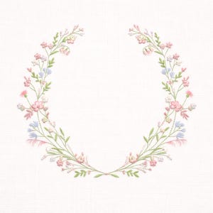 Puede incluir: Un diseño de corona floral bordada con flores rosas, azules y blancas con hojas verdes. La corona está dispuesta en forma circular, perfecta para proyectos de bordado, tarjetas u otras manualidades.
