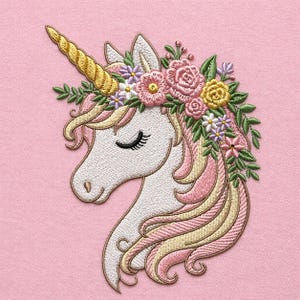 Könnte beinhalten: Gestickter Einhornkopf mit goldenem Horn, geschlossenen Augen und Blumenkranz. Die Mähne ist rosa und gelb, vor einem einfarbigen rosa Hintergrund. Die Stickerei ist detailliert und das Design ist skurril.