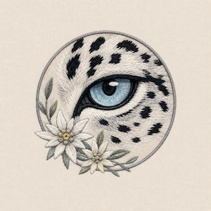 Può includere: Una toppa ricamata circolare che presenta l'occhio dettagliato di un leopardo con un'iride blu brillante e una pupilla nera, circondato da pelliccia bianca con macchie nere. Due fiori di stella alpina bianchi con foglie verdi sono ricamati in basso a sinistra.